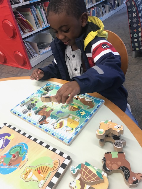 Young child working on a puzzle at a table
